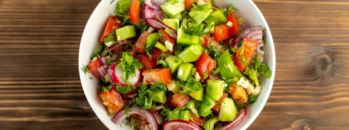 fresh-vegetables-colorful-sliced-such-as-cucumbers-red-tomatoes-onion-wooden-rustic-surface